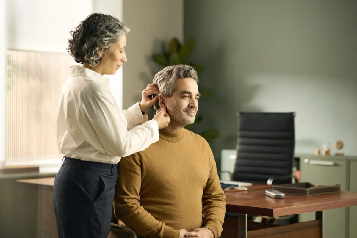 Avdiologinja s pacientom prilagaja slušni aparat Danavox