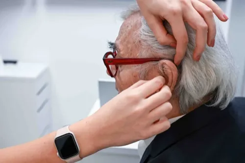 Avdiologinja Danavox s slušnim aparatom v roki