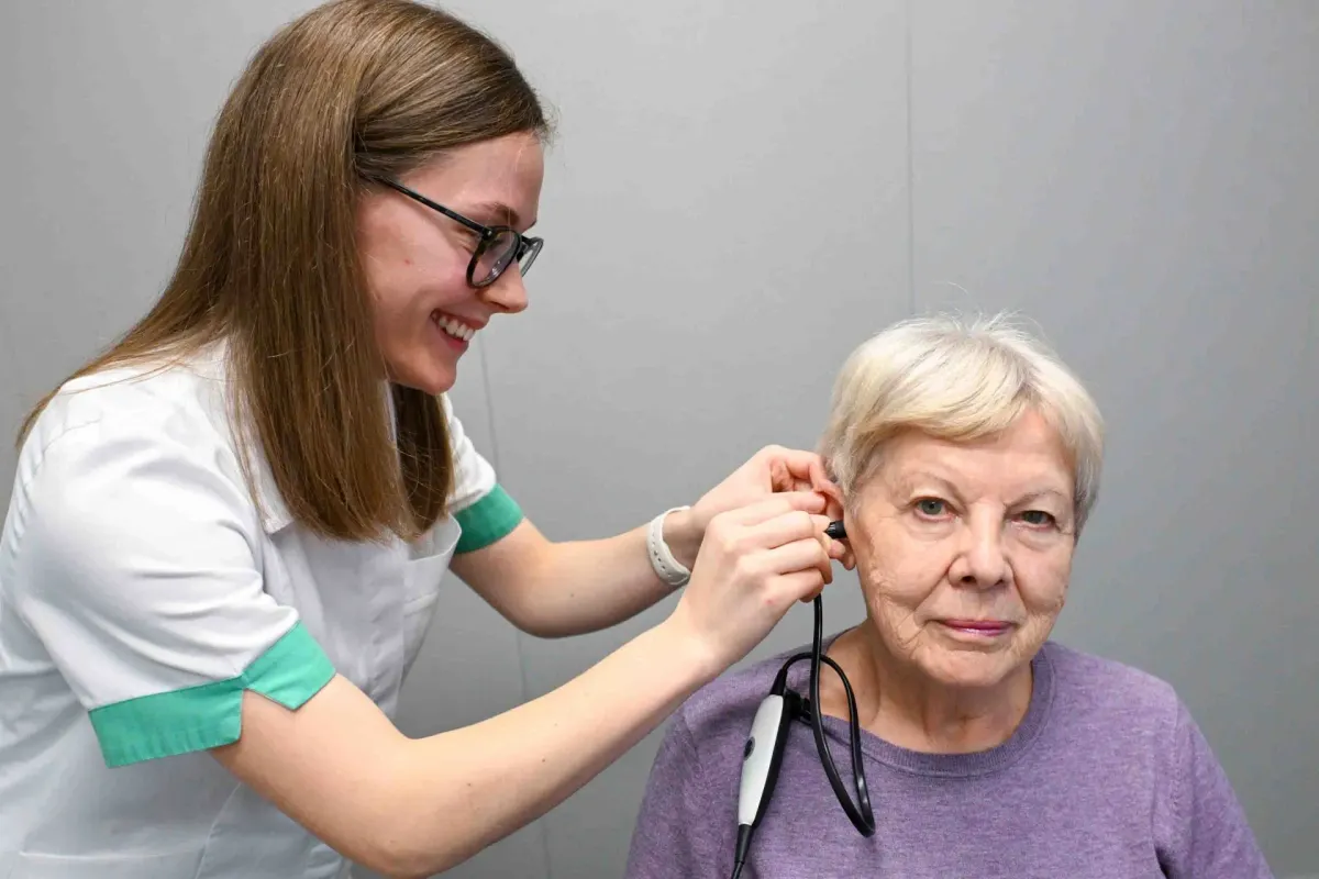 Pregled ušesa z otoskopom v ordinaciji ORL medicina